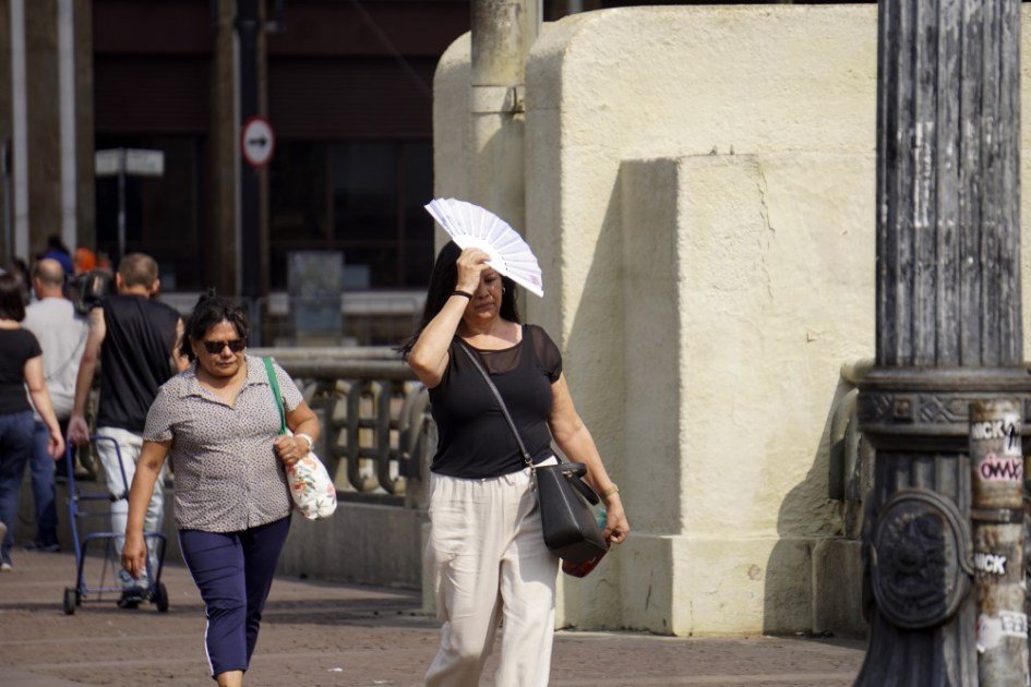 Mulher usa leque em dia de calor