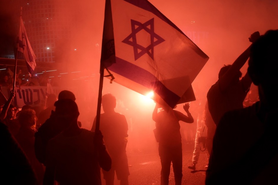 Um manifestante segura uma bandeira israelense durante um comício para pedir um acordo de reféns em Tel Aviv