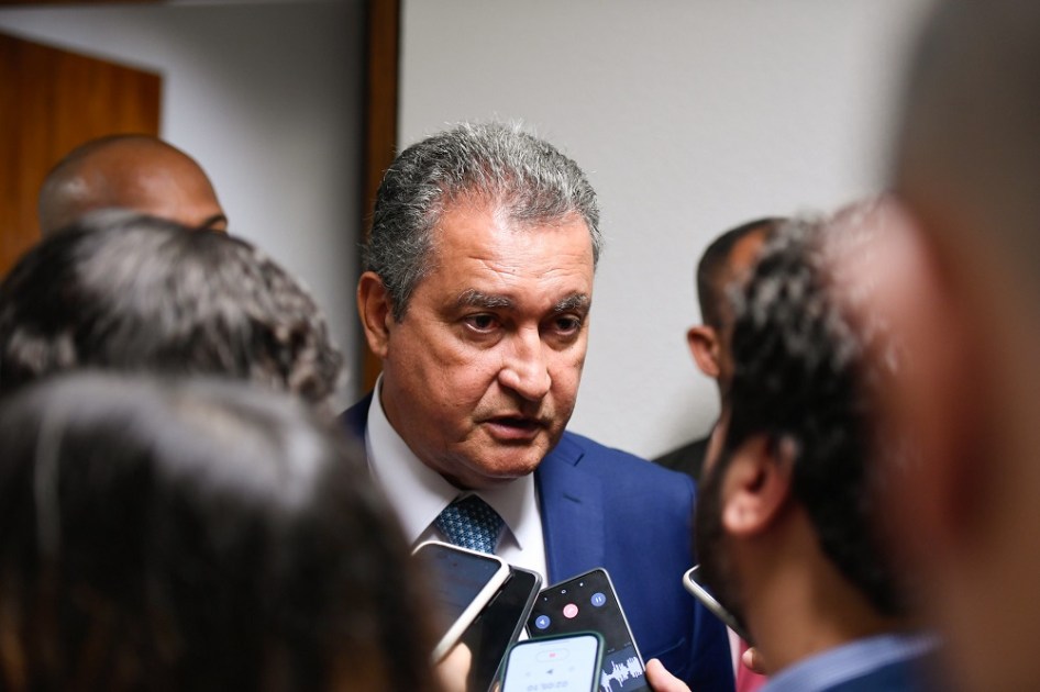 Rui Costa dá entrevisa coletiva, cercado por microfones