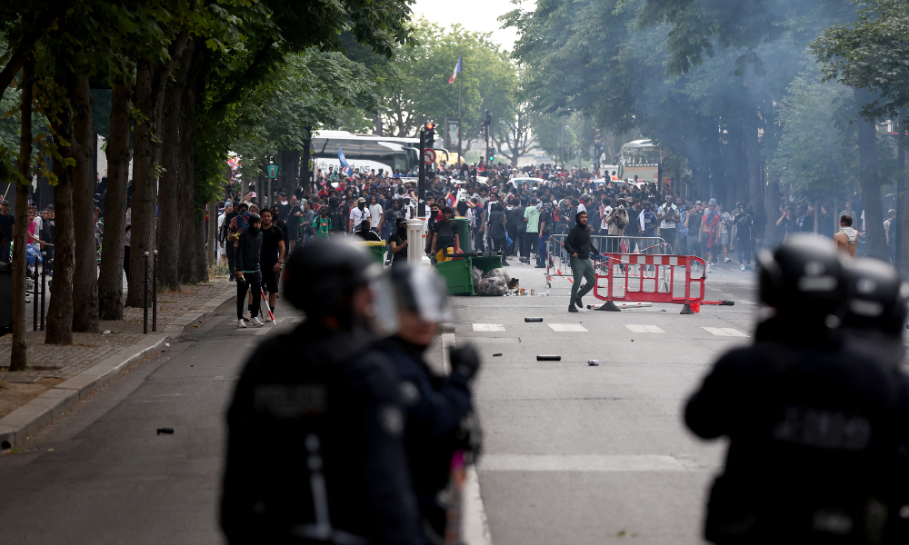 Policiais entram em confronto com a multidão após o desfile do ônibus do time do PSG, nas proximidades da avenida Champs-Elysées, em Paris, em 1º de junho de 2025, um dia após o PSG vencer a final da Liga dos Campeões da UEFA 2025 contra a Inter de Milão, em Munique. (Foto de Romain PERROCHEAU / AFP)