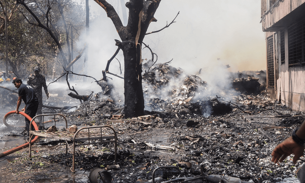 Bombeiros trabalham no local onde o voo 171 da Air India caiu em uma área residencial próxima ao aeroporto de Ahmedabad, em 12 de junho de 2025. O avião de passageiros, com destino a Londres, caiu na cidade de Ahmedabad, no oeste da Índia, com 242 pessoas a bordo, segundo autoridades da aviação, em um acidente que a companhia aérea classificou como "tragédia". (Foto: Sam Panthaky / AFP)
