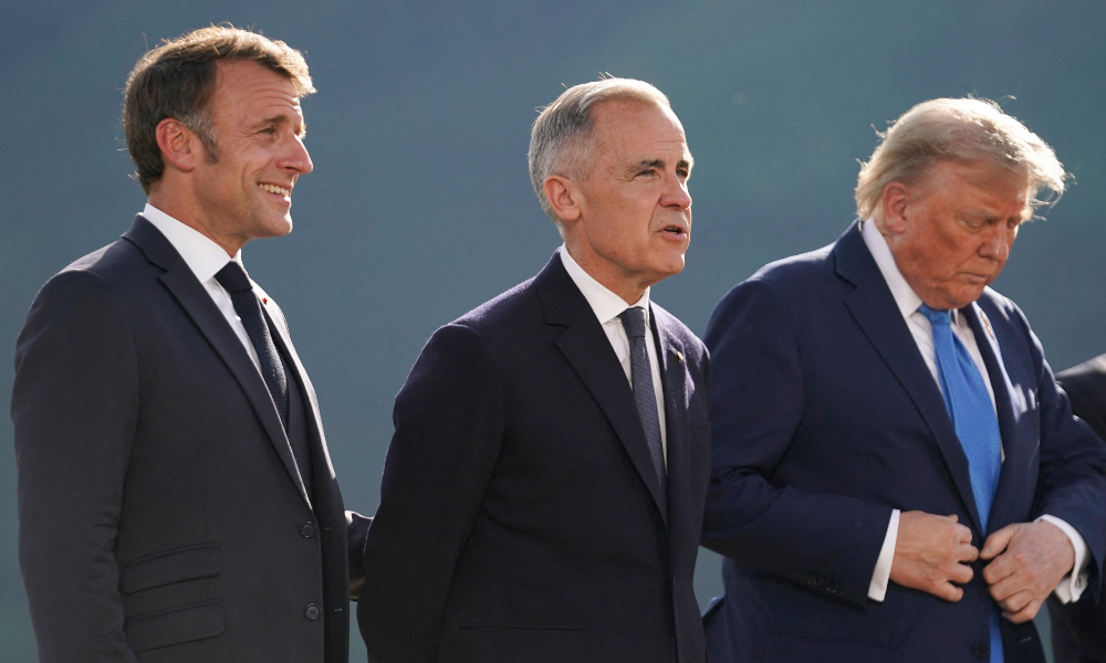 (Da esquerda para a direita) O presidente francês Emmanuel Macron, o primeiro-ministro canadense Mark Carney e o presidente dos EUA Donald Trump posam para uma foto de família durante a Cúpula do Grupo dos Sete (G7) no campo de golfe Kananaskis Country em Kananaskis, Alberta, Canadá, em 16 de junho de 2025. (Foto de Geoff Robins / AFP)