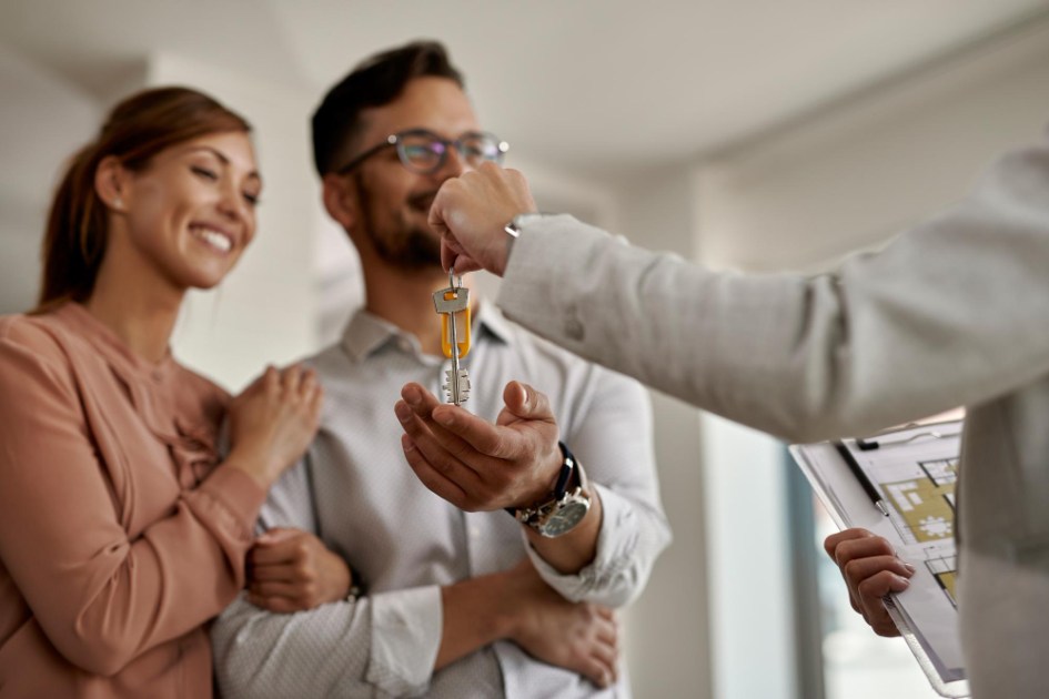 Close de um agente imobiliário dando a algumas chaves de sua nova casa