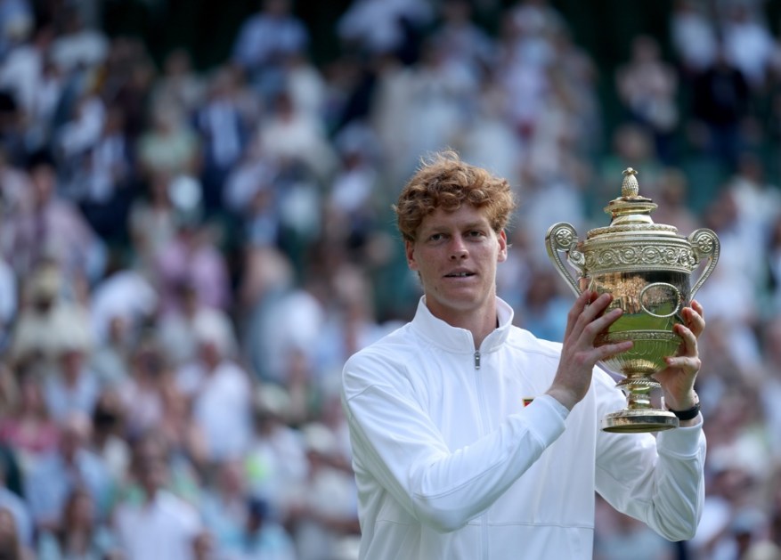 O italiano Jannik Sinner comemora com o troféu após vencer a final de simples masculina contra o espanhol Carlos Alcaraz no torneio de Wimbledon