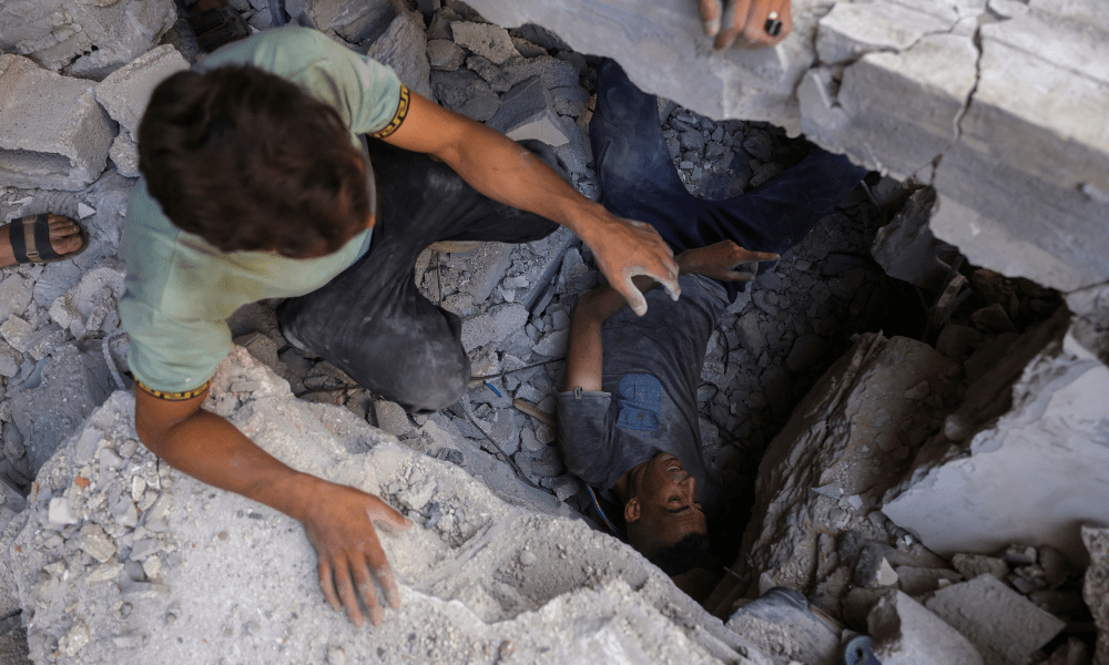 Palestinos procuram sobreviventes nos escombros de um prédio no bairro de Sheikh Radwan, na Cidade de Gaza, no centro da Faixa de Gaza, alvo de um ataque israelense em 6 de julho de 2025. Uma delegação israelense era esperada em Doha em 6 de julho para negociações sobre uma trégua em Gaza e um acordo para a libertação de reféns, após o grupo palestino Hamas afirmar estar pronto para iniciar as negociações "imediatamente". (Foto de Bashar TALEB / AFP)