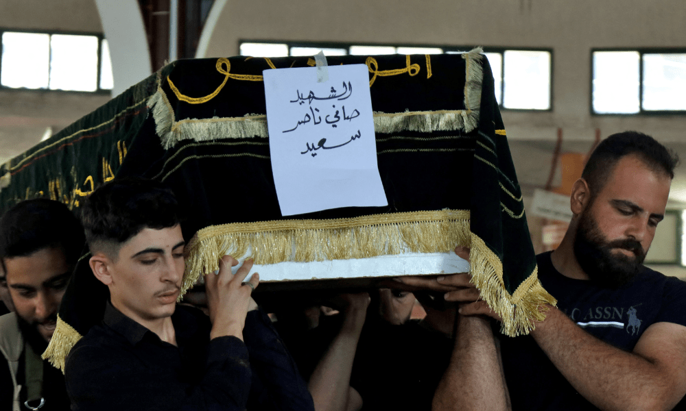 Pessoas em luto carregam o corpo de um homem morto durante confrontos entre combatentes drusos e tribos beduínas, durante seu funeral na cidade síria predominantemente drusa de Sweida, em 14 de julho de 2025. Negociações estão em andamento entre autoridades sírias e representantes drusos no sul da Síria para encerrar os confrontos que mataram quase cem pessoas desde domingo, disse um grande grupo armado druso à AFP em 14 de julho. (Foto de Shadi AL-DUBAISI / AFP)