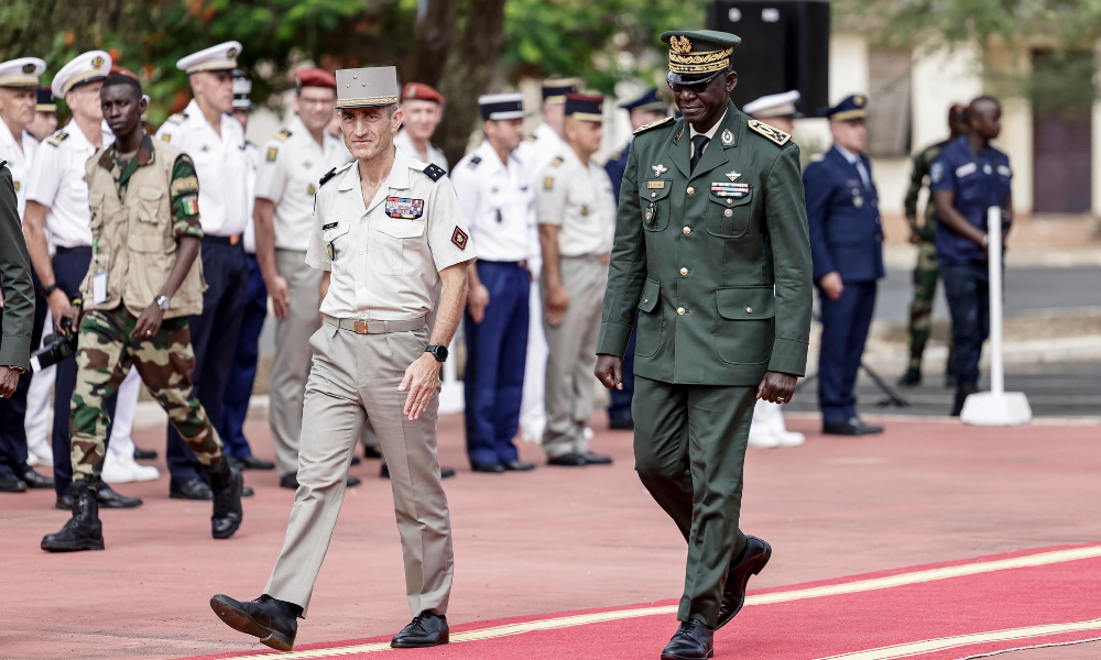 O Chefe do Estado-Maior do Senegal, General Mbaye Cisse (à direita), e o General francês Pascal Ianni (à esquerda), que comanda as tropas francesas na África, caminham em direção a um mastro onde a bandeira senegalesa será hasteada durante uma cerimônia na qual a França devolverá o Camp Geille, sua maior base no país, e seu aeródromo no aeroporto de Dacar, em 17 de julho de 2025. A França devolverá formalmente, em 17 de julho de 2025, suas últimas bases militares no Senegal, deixando o exército francês sem acampamentos permanentes na África Ocidental e Central. Encerrando os 65 anos do exército francês no Senegal, a retirada ocorre após retiradas semelhantes em todo o continente, com as ex-colônias cada vez mais dando as costas ao seu antigo governante. Cerca de 350 soldados franceses, encarregados principalmente de conduzir operações conjuntas com o exército senegalês, deixarão o país da África Ocidental após um processo de retirada de três meses. A França começou a ceder suas bases ao Senegal em março. (Foto de Patrick Meinhardt / AFP)