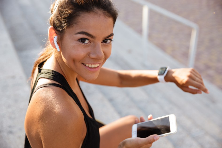 Retrato de uma mulher de fitness sorridente em fones de ouvido