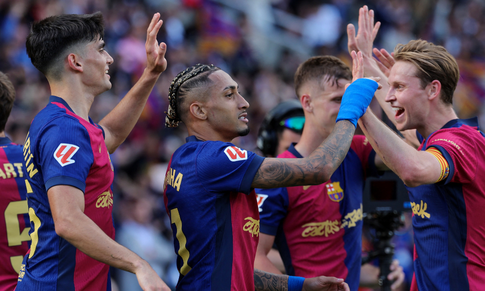 O atacante brasileiro do Barcelona, Raphinha (#11), comemora com os companheiros o quarto gol da equipe durante a partida do Campeonato Espanhol entre FC Barcelona e Real Madrid, no Estadi Olímpic Lluís Companys, em Barcelona, em 11 de maio de 2025.