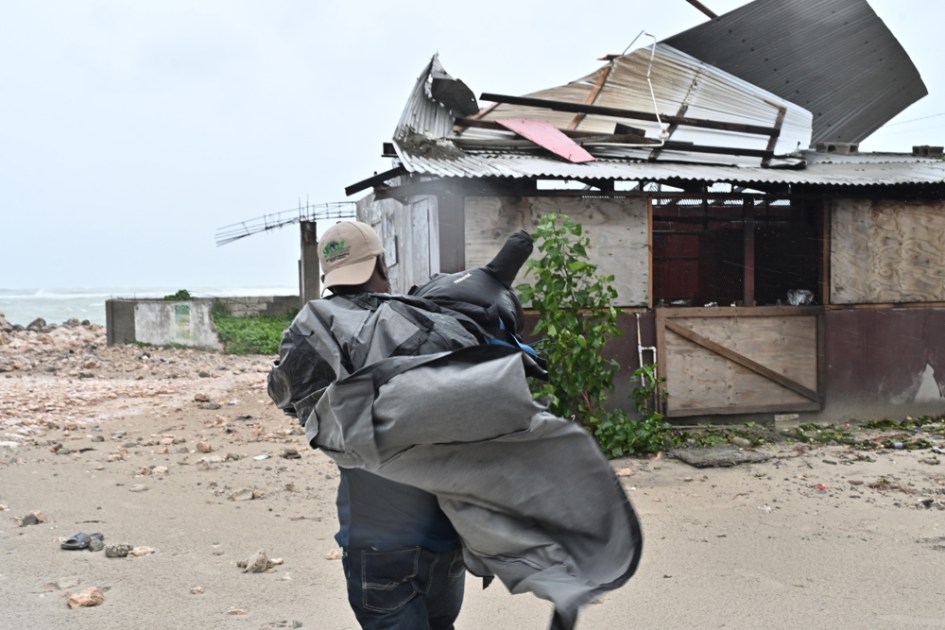 Um homem carregou uma lona para cobrir o tecido de uma casa antes do passo do furacão Melissa é uma lua, na praia pesqueira de Hellshire, em Portmore (Jamaica). O primeiro-ministro da Jamaica, Andrew Holness, garantiu que o governo contou com um plano multifacético para levar ao cabo uma resposta "rápida e eficaz" antes do iminente impacto na noite desta lua do furacão Melissa no país caribenho. EFE/Rudolph Brown