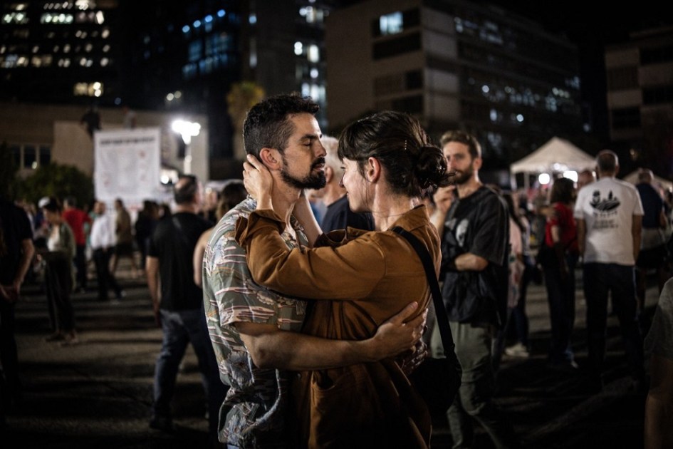 Um casal se abraça na Praça dos Reféns, em Tel Aviv, em 9 de outubro de 2025, durante um encontro após o anúncio do novo acordo de cessar-fogo em Gaza