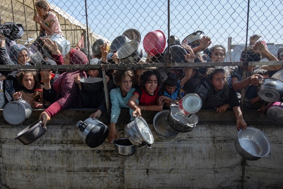 Palestinos deslocados internos se reúnem em frente a uma cozinha beneficente para receber rações limitadas em meio à escassez de alimentos, em Khan Younis, sul da Faixa de Gaza, 30 de maio de 2025 (reeditado em 6 de outubro de 2025). 7 de outubro de 2025 marca dois anos desde que o grupo militante palestino Hamas lançou um ataque surpresa contra Israel, fazendo dezenas de reféns e matando quase 1.200 pessoas. Em resposta, Israel iniciou sua guerra contra Gaza, que já matou mais de 66.000 pessoas, deslocou milhões e destruiu o enclave palestino. EFE/EPA/HAITHAM IMAD