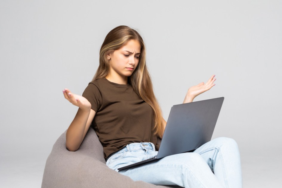 Mulher deprimida e frustrada que trabalha com o laptop do computador