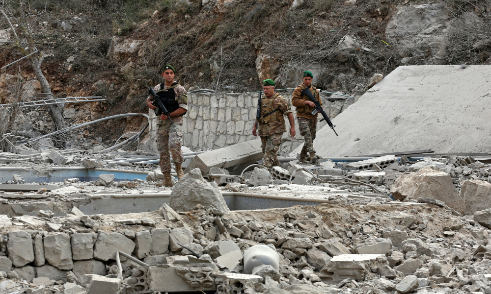 Soldados do exército libanês inspecionam o local de um ataque aéreo israelense na vila de Tair Felsay, no sul do Líbano, perto do rio Litani, na madrugada de 13 de novembro de 2025. (Foto de MAHMOUD ZAYYAT / AFP)