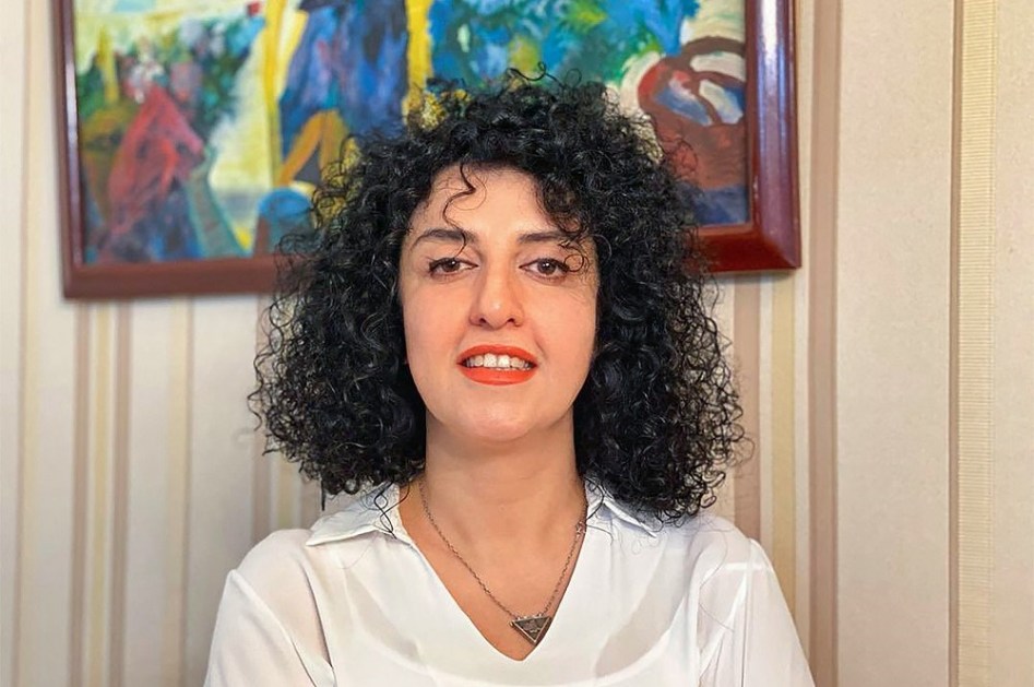 Narges Mohammadi em frente a um quadro e sem vestes islâmicas