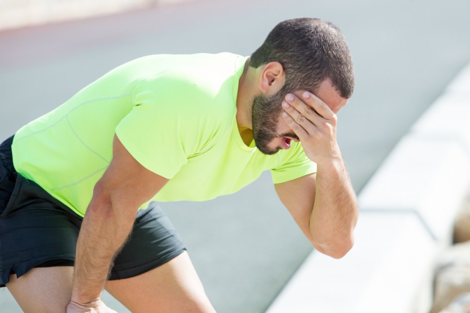 Homem leva mão aos olhos após passar mal durante exercício