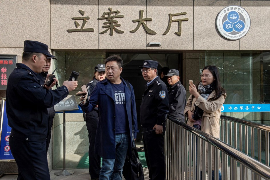Foto de 31 de outubro de 2019 mostra o advogado Xie Yang conversando com seguranças do Tribunal Popular Intermediário de Xuzhou sobre a prisão do colega Yu Wensheng, também ativista dos direitos humanos