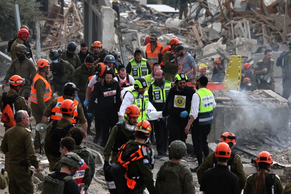 Agentes do serviço de emergência israelense removem um saco mortuário do local de um ataque de mísseis perto de Bet Shemesh, a cerca de 30 quilômetros a oeste de Jerusalém, em 1º de março de 2026.