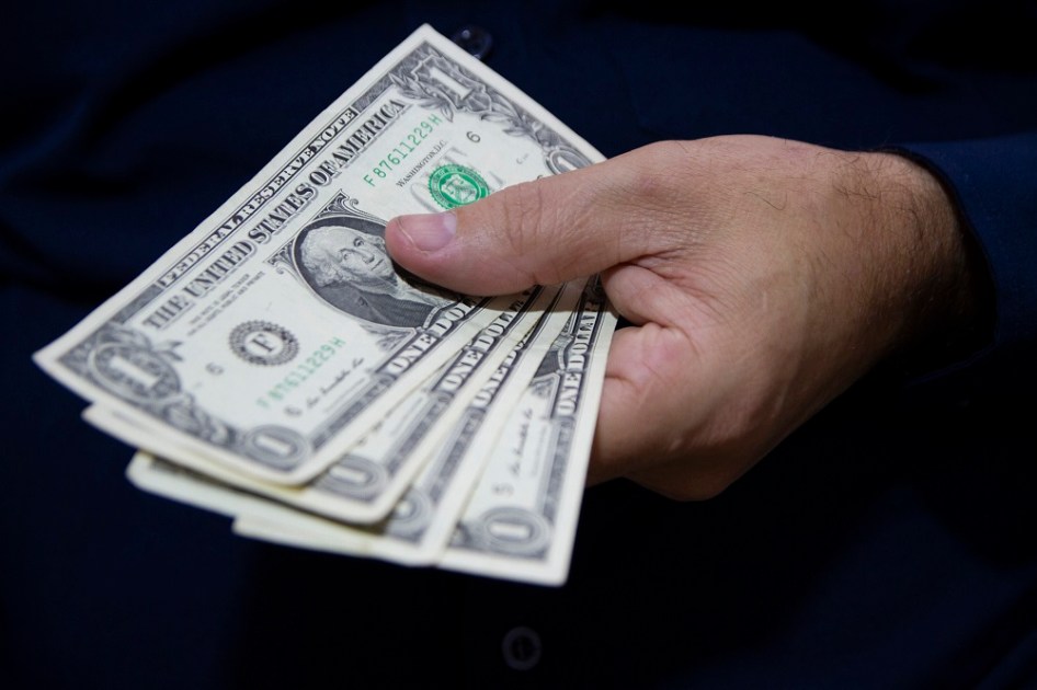 Mã com três notas de dólar