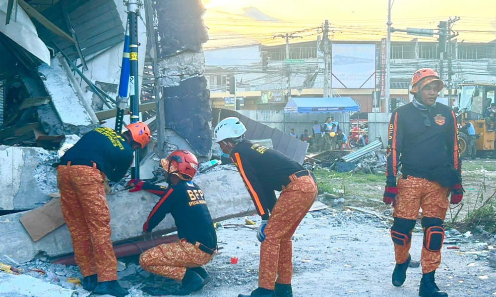 Equipes de resgate realizam uma operação de salvamento em um prédio que desabou após o terremoto de magnitude 7,8 na cidade de General Santos, nas Filipinas