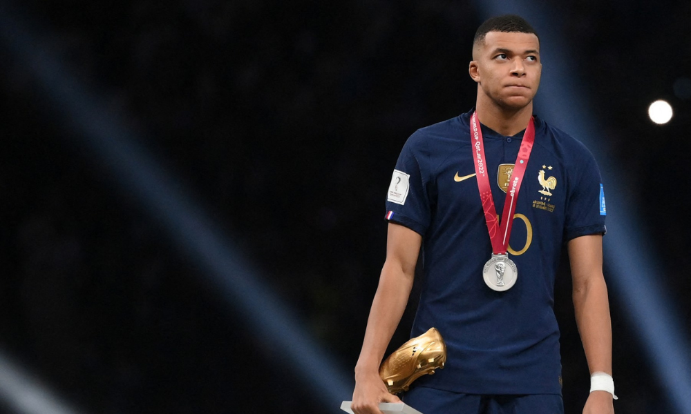 Kylian Mbappé com sua Chuteira de Ouro após receber a medalha de prata durante a cerimônia de entrega do troféu da Copa do Mundo do Catar 2022