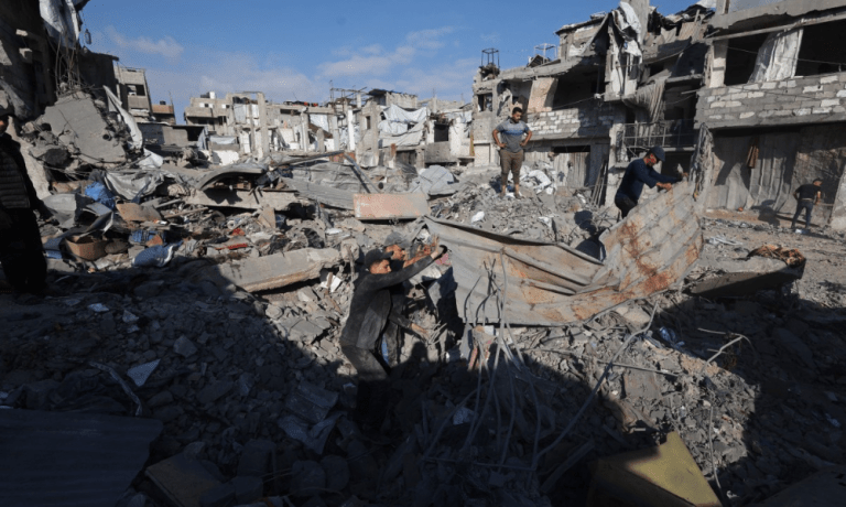 Palestinos inspecionam o local de um ataque israelense no campo de refugiados de Bureij, no centro da Faixa de Gaza