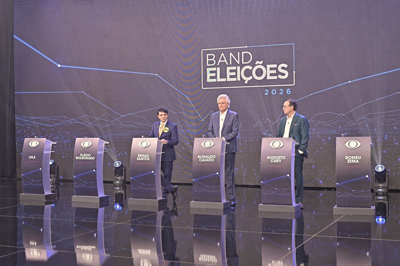 Ausentes, Lula e Flávio protagonizam 1º debate e são atacados por candidatos