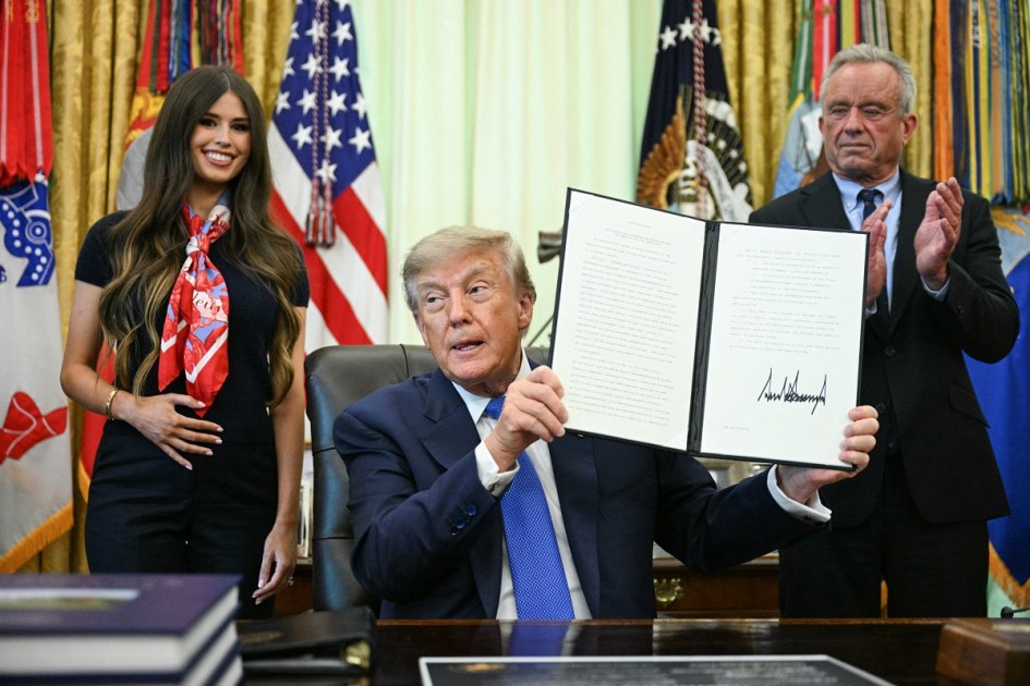 O presidente dos EUA, Donald Trump, assina uma ordem executiva solicitando mais pesquisas e flexibilidade em relação às vacinas, ao lado do secretário de Saúde e Serviços Humanos dos EUA, Robert F. Kennedy Jr. (à direita), e de Jayme Leagh Franklin (à esquerda), fundadora do *The Conservateur*, no Salão Oval da Casa Branca, em Washington, D.C., em 10 de agosto de 2026. Trump assinou uma ordem executiva na segunda-feira defendendo uma revisão das exigências de vacinação escolar e reiterando pedidos para que a vacina contra sarampo, caxumba e rubéola seja desmembrada em três doses individuais. A restrição às vacinas tem sido uma prioridade fundamental para o secretário de Saúde, Robert F. Kennedy Jr., que fundou uma organização sem fins lucrativos antivacina e há muito promove a ideia — já refutada — de uma ligação entre a imunização e o autismo. (Foto de Jim WATSON / AFP)
