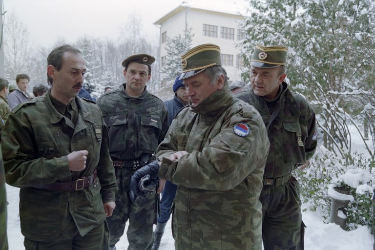 (Arquivos) O general sérvio-bósnio Ratko Mladic (segundo a partir da direita) olha para o relógio no quartel de Lukavica, nos arredores de Sarajevo, em 15 de fevereiro de 1994. O ex-líder militar sérvio-bósnio e criminoso de guerra Ratko Mladic morreu em um hospital prisional em Haia — segundo a emissora estatal sérvia RTS, em 27 de agosto de 2026 — após sofrer vários derrames. Mladic, aos 84 anos, ficou conhecido como o "Açougueiro da Bósnia" por seu papel no massacre de Srebrenica, em 1995, durante a Guerra da Bósnia. (Foto de Pascal GUYOT / AFP)