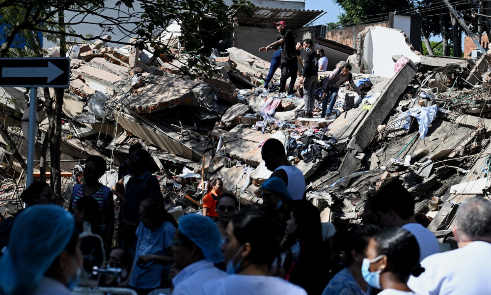 Pessoas trabalham em prédio que desabou após o terremoto em Cali, na Colômbia, nesta segunda-feira (10)