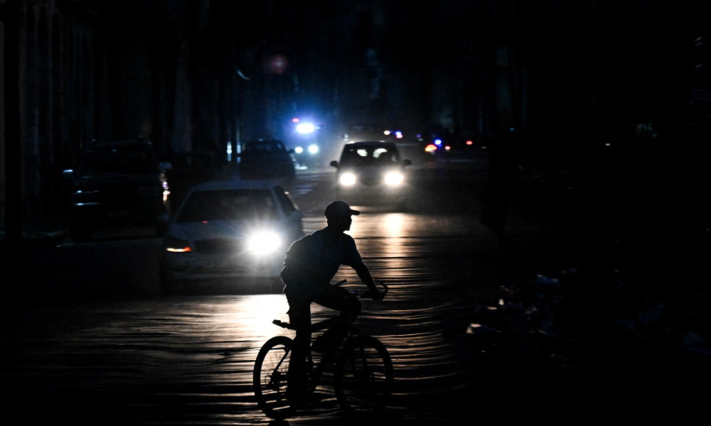 Homem pedala em sua bicicleta por uma rua durante o apagão em Havana