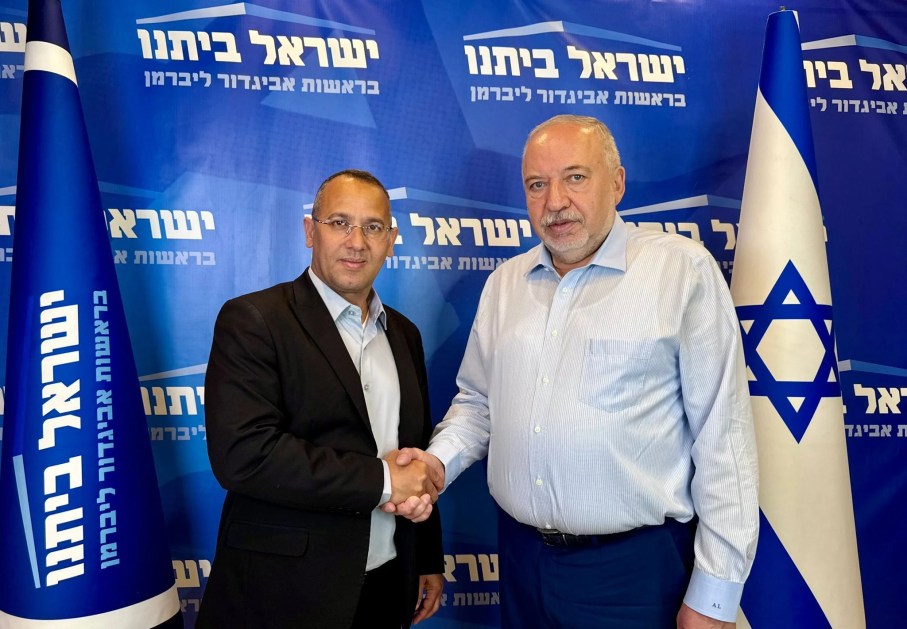 Sharon Sharabi (à esq.) aperta a mão de Avigdor Liberman (à direita) em uma foto de maio de 2026
