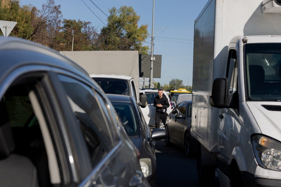 Um homem está em meio a carros parados em engarrafamentos em Kiev, em 2 de outubro de 2026, durante a invasão russa da Ucrânia. O trânsito ficou paralisado em Kiev em 2 de outubro de 2026, após o fechamento de uma das principais pontes da cidade e a imposição de restrições em outras, na sequência de mais uma onda de ataques russos com drones. (Foto de Tetiana DZHAFAROVA / AFP)