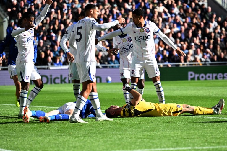 O goleiro argentino do Chelsea, número 26 Emiliano Martínez, e o zagueiro inglês do Everton, número 04 Jarrad Branthwaite, estão caídos, machucados, após uma dividida durante a partida de futebol da Premier League Inglesa entre Everton e Chelsea no Estádio Hill Dickinson, em Liverpool, no noroeste da Inglaterra, em 17 de outubro de 2026